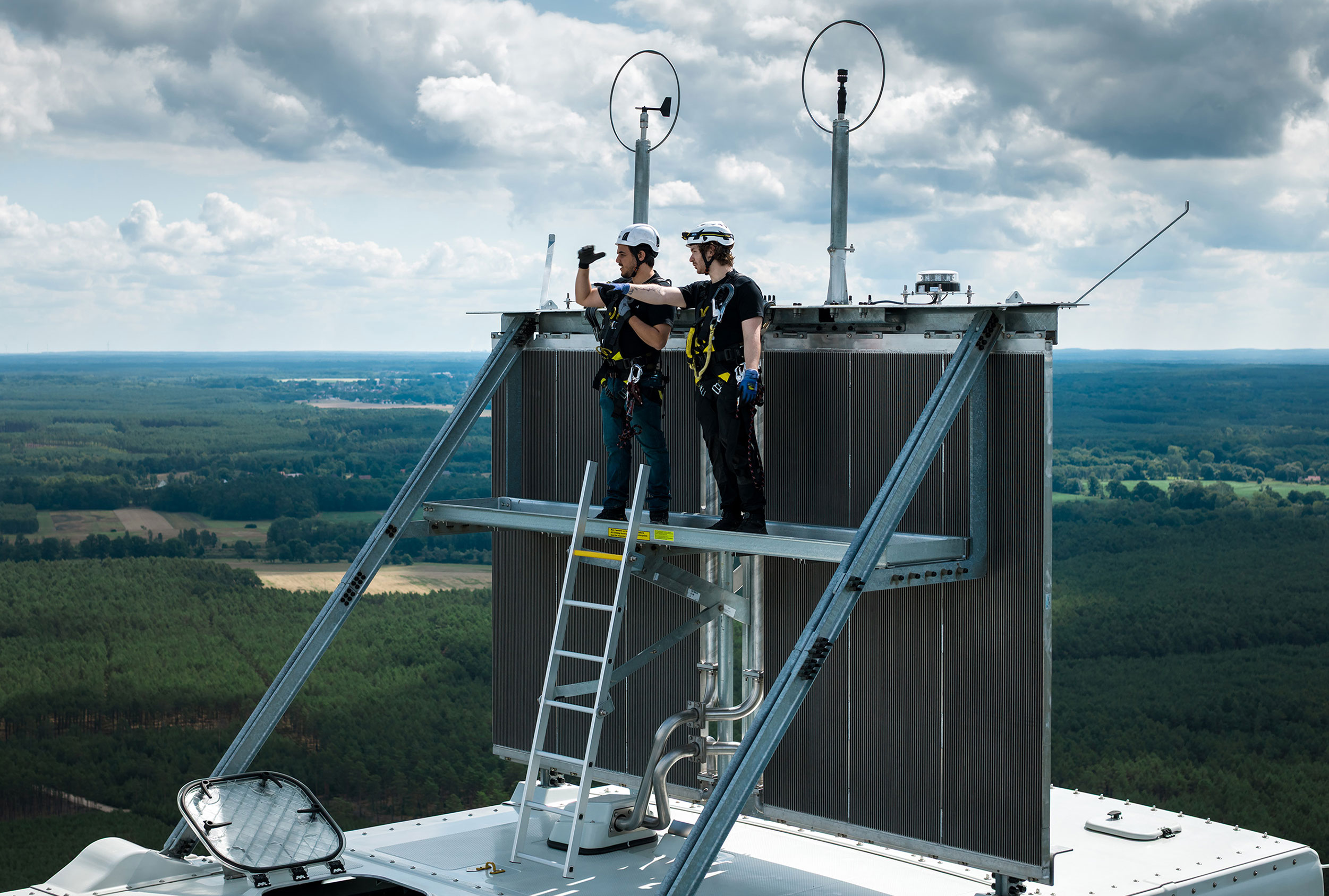 Zwei Betriebsführer von Perigus Energy stehen auf einer Windenergieanlage.
