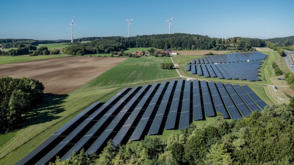 Luftaufnahme des Solarparks Hatzenhof, im Hintergrund der Windpark Granswang.